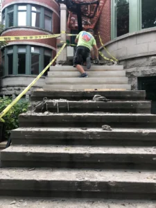 New limestone historic front steps being set with a boom lift, Chicago