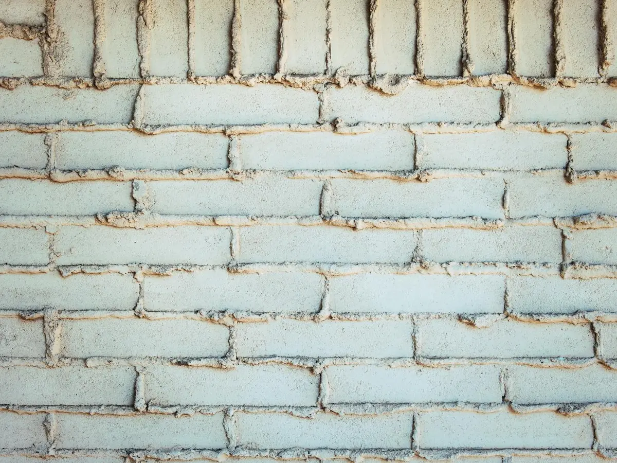 Weathered brick wall with eroded, recessed mortar joints.